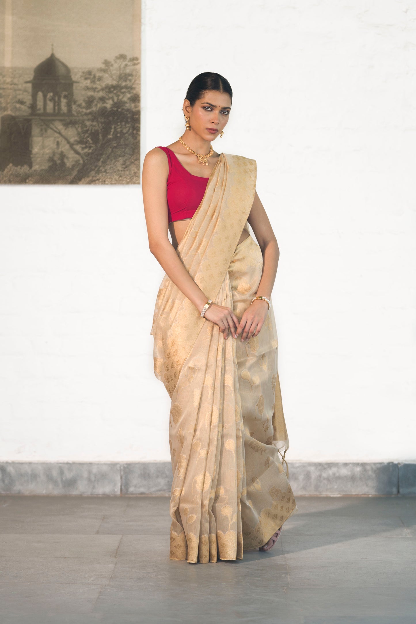 Golden Tissue Saree woven in Floral Motifs paired with scallop style border and rich palla