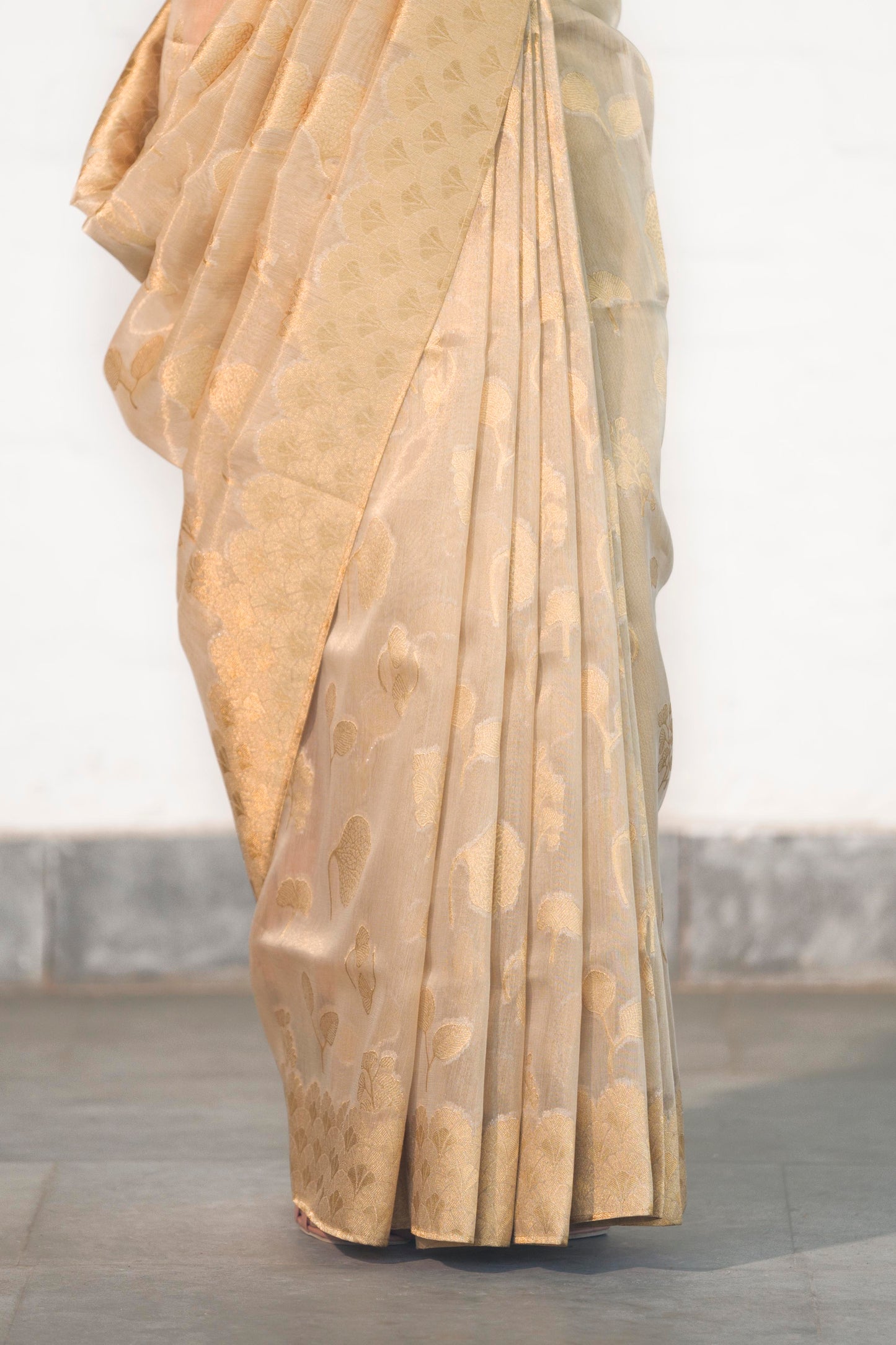 Golden Tissue Saree woven in Floral Motifs paired with scallop style border and rich palla