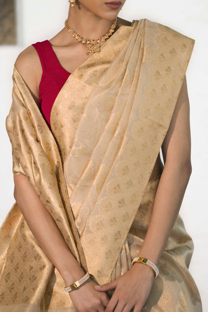 Golden Tissue Saree woven in Floral Motifs paired with scallop style border and rich palla