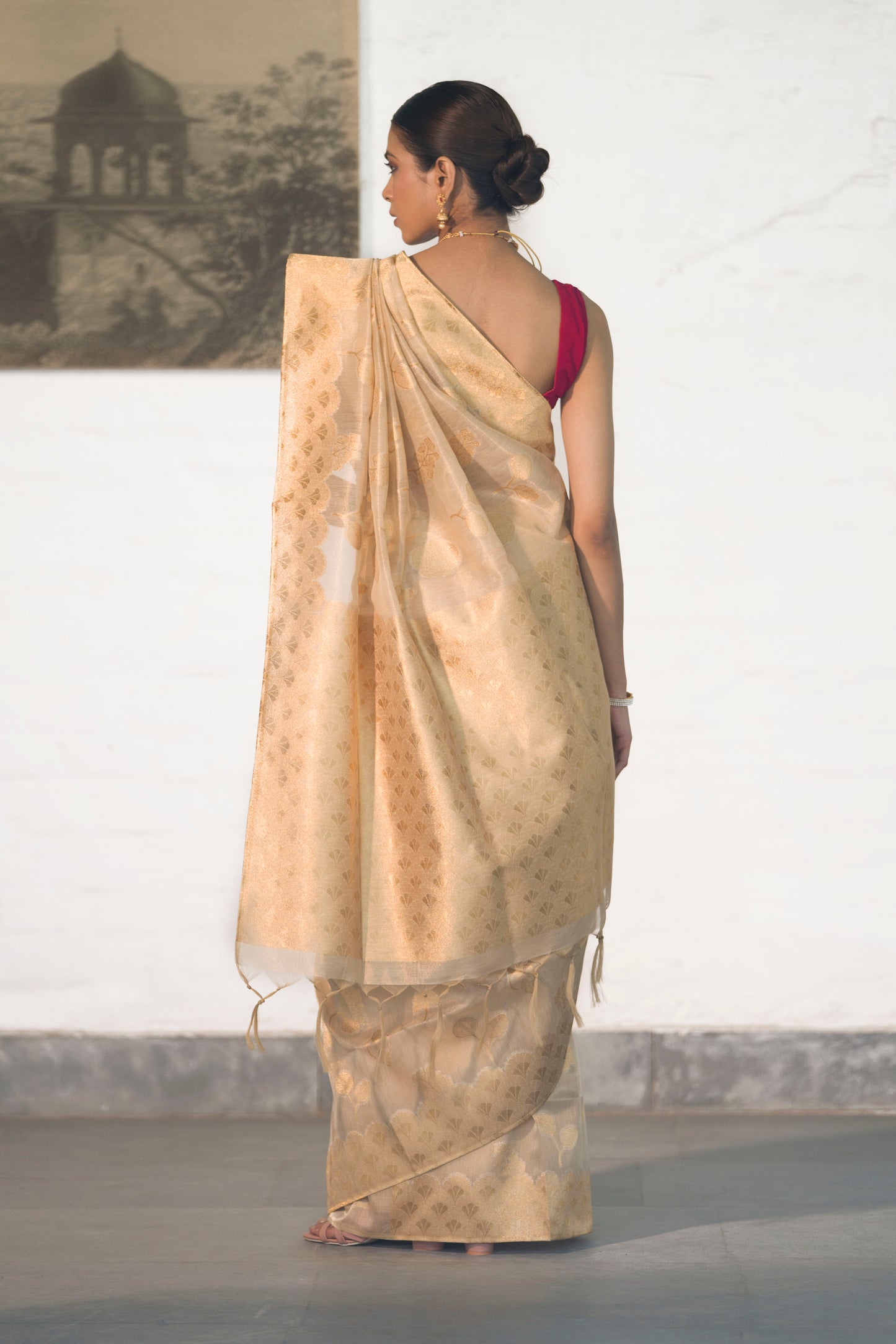 Golden Tissue Saree woven in Floral Motifs paired with scallop style border and rich palla